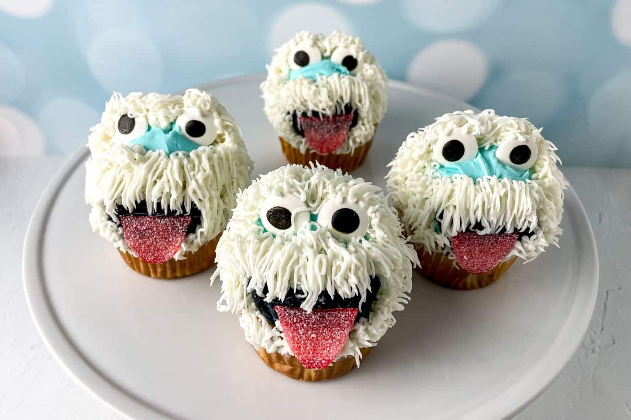 Snowman-themed cupcakes with fluffy white frosting and candy eyes.