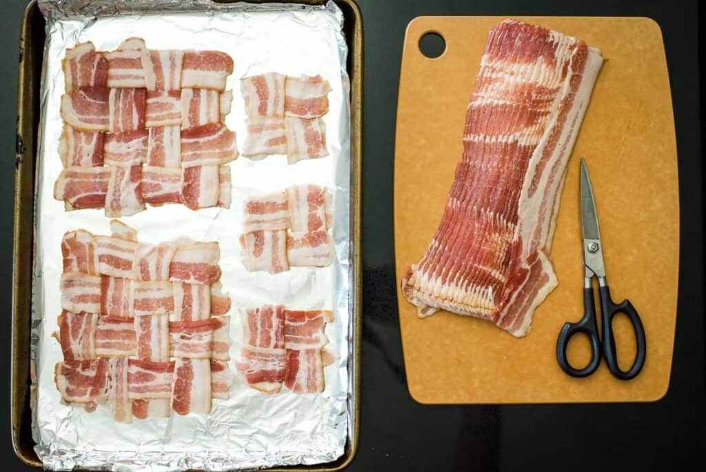 Bacon slices woven on a baking sheet with foil on the left and a stack of uncooked bacon with scissors on a cutting board on the right.