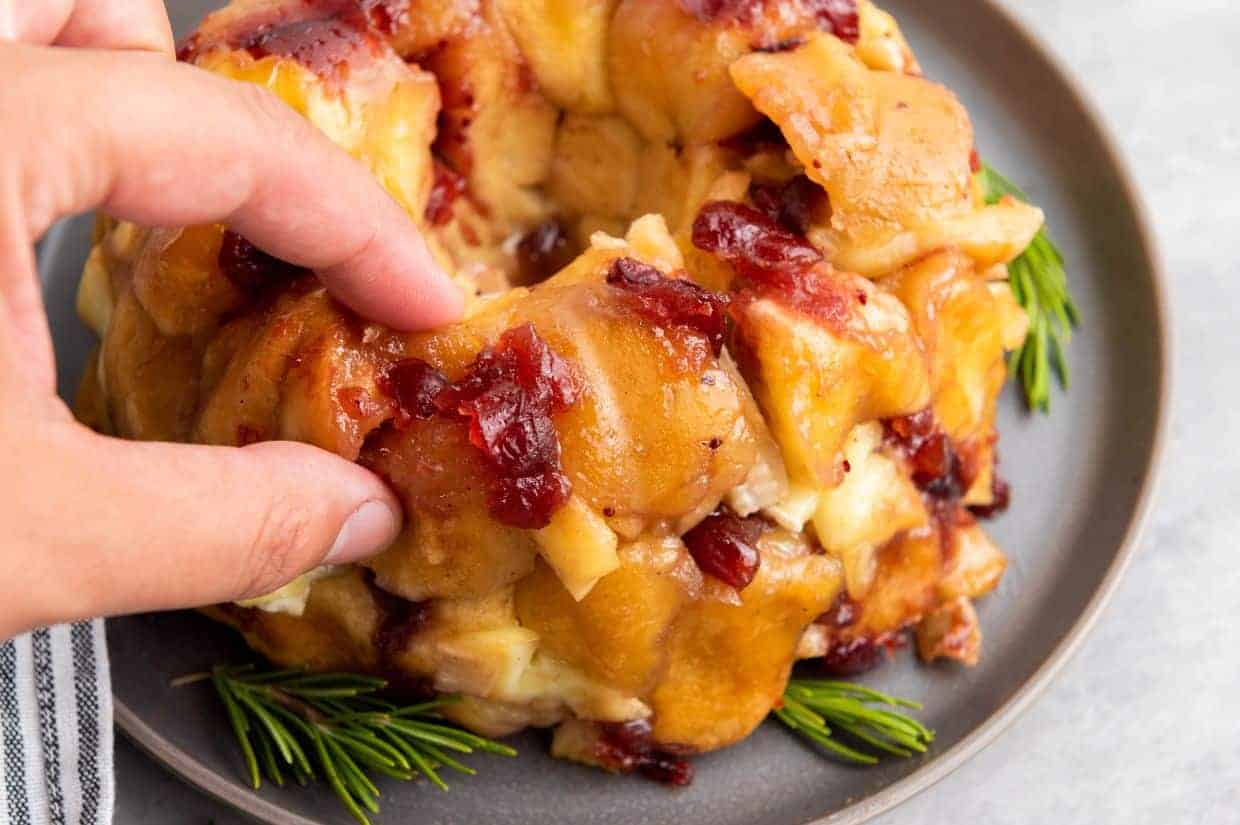 Golden pull-apart bread topped with cranberry sauce and melted brie cheese.