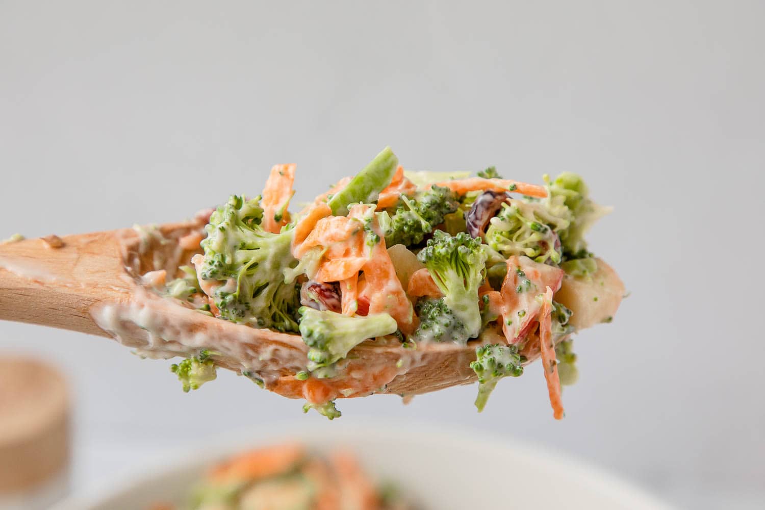 Broccoli and shredded carrots on a mixing spoon.