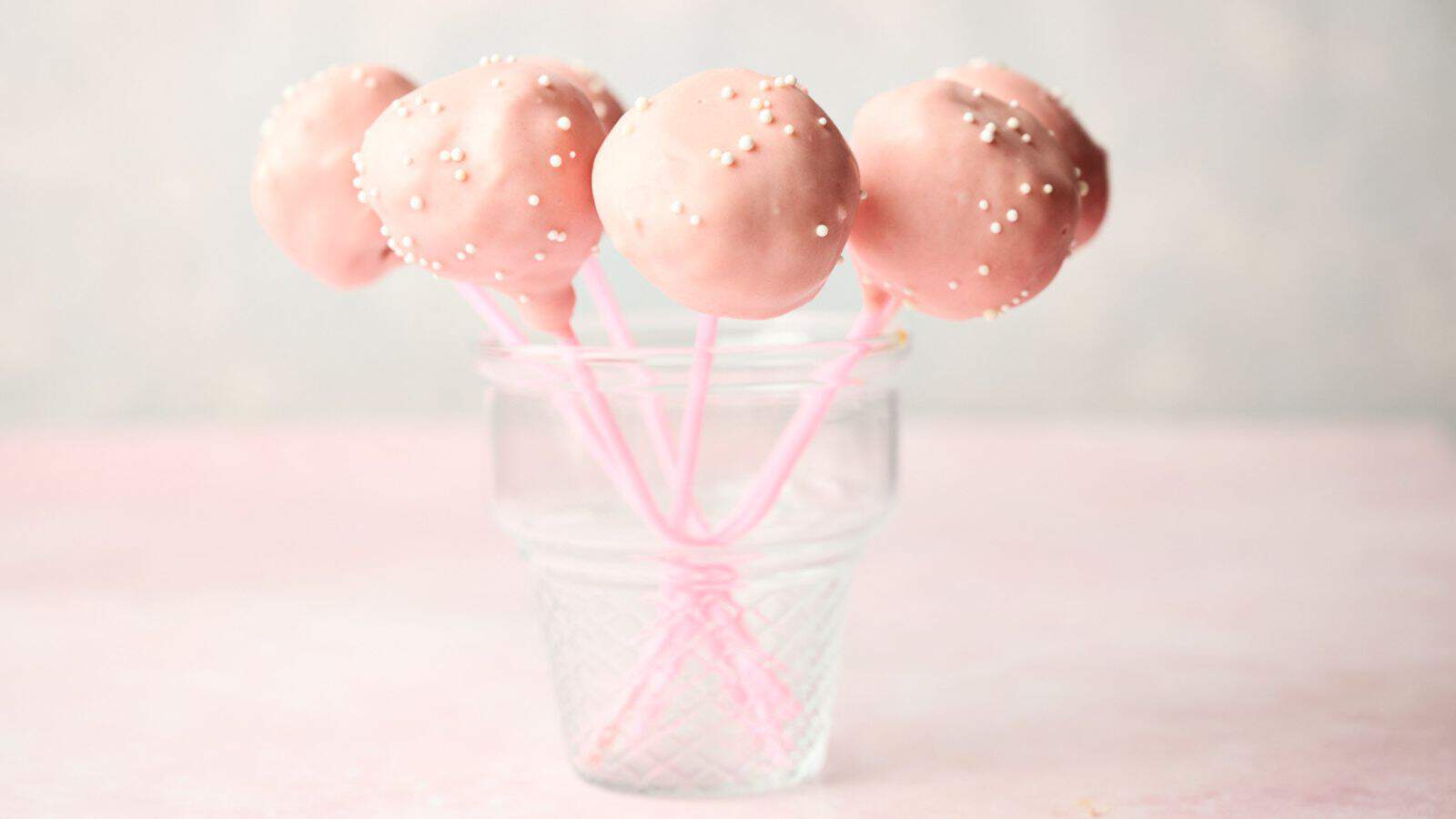 Starbucks pink cake pops in a glass on a table.