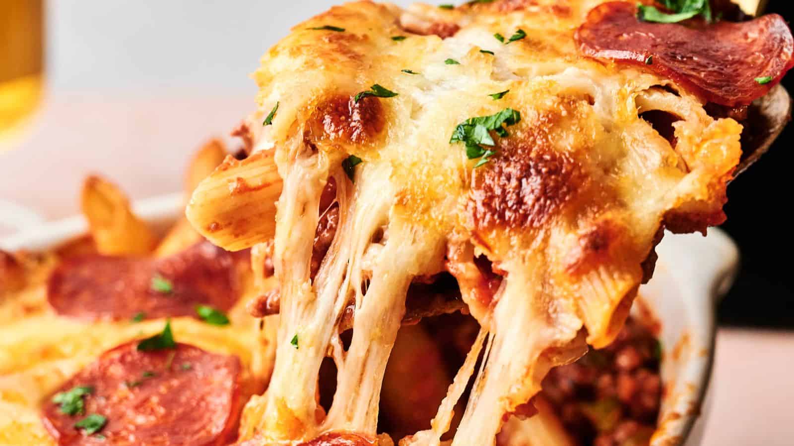 A slice of cheesy pepperoni pizza being lifted, with melted cheese stretching.