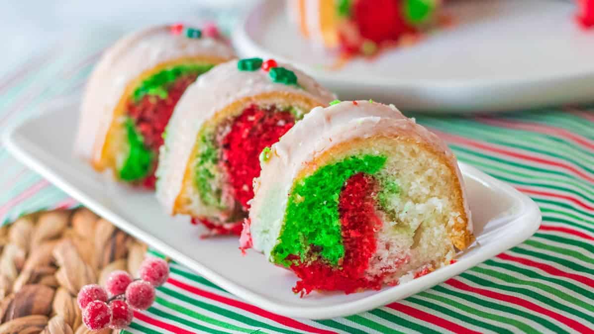 A festive Christmas bundt cake on a plate with a generous drizzle of icing.