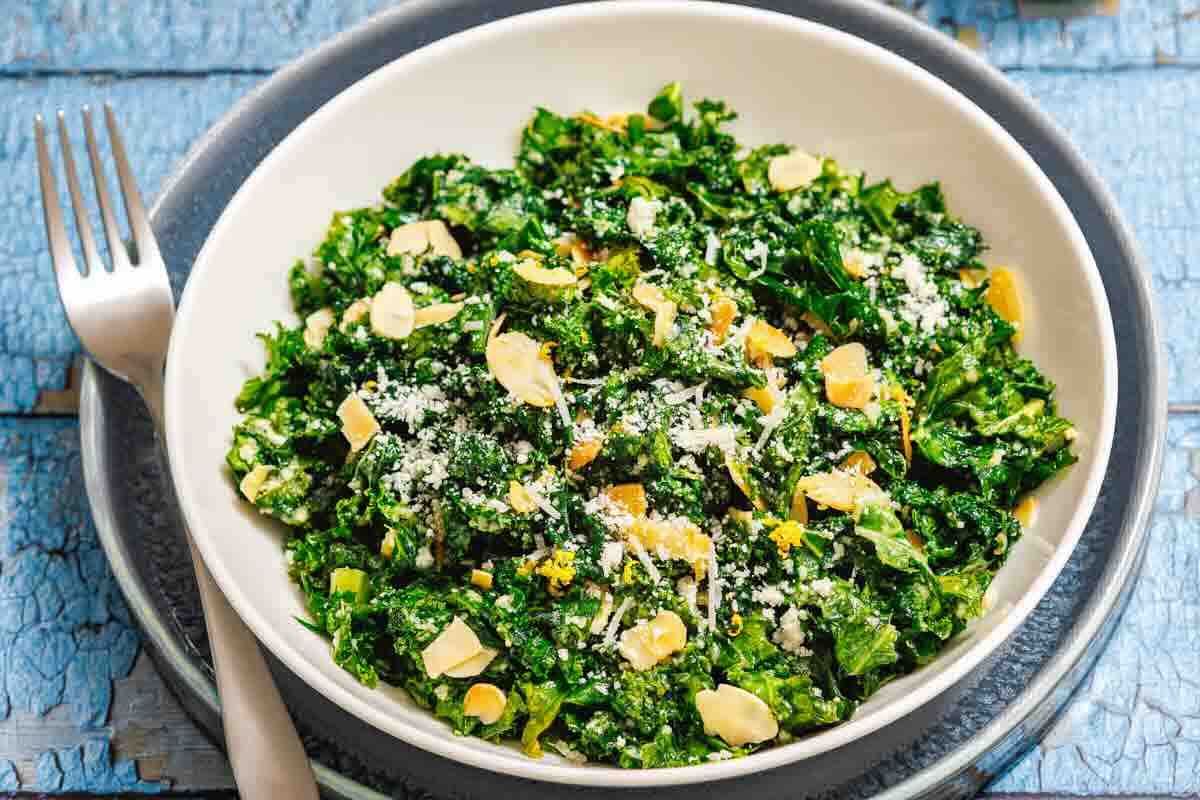 Green kale salad topped with sliced almonds.