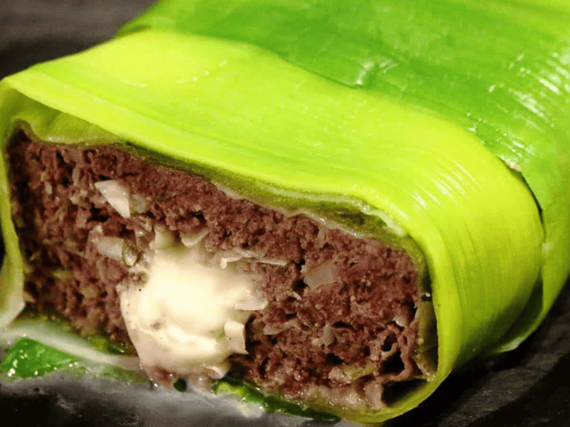 Meatloaf with cheese wrapped in green leek.