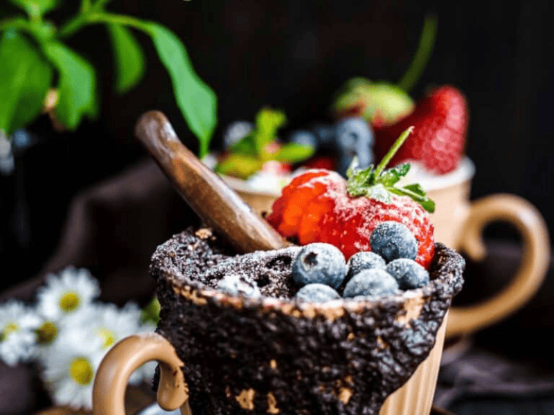 Chocolate Mug Cake with berries on top.