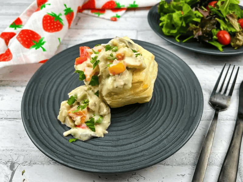 A plate with a Turkey &agrave; la King and salad on it.