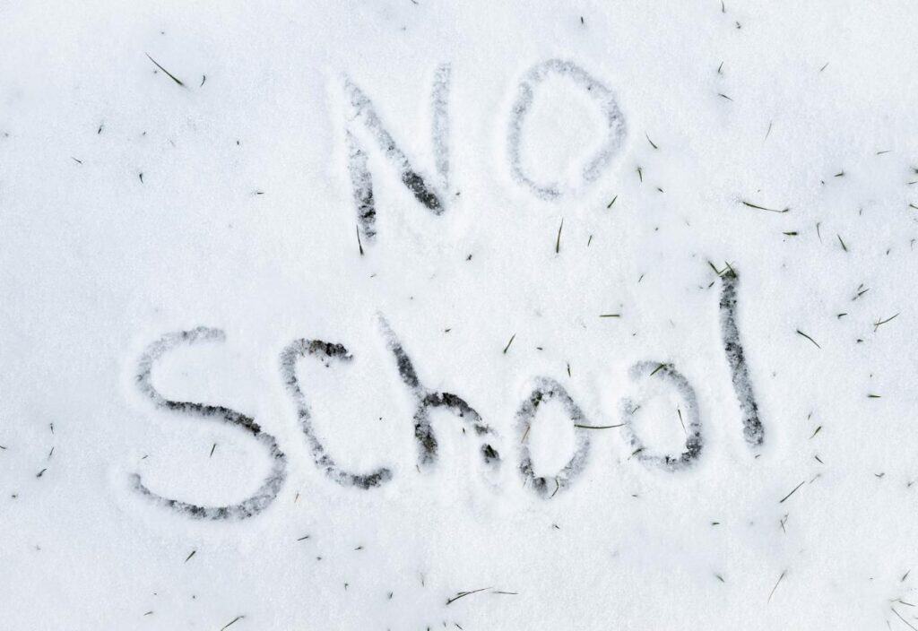 The words "NO SCHOOL" are written in the snow, with some grass peeking through the white surface&mdash;a perfect scene to announce school closings.