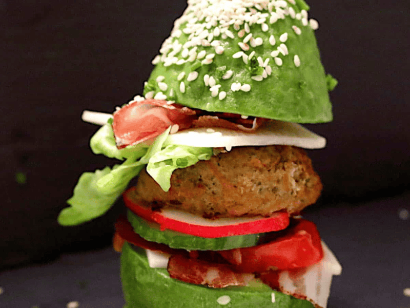 A burger stuck in between avocado as buns.