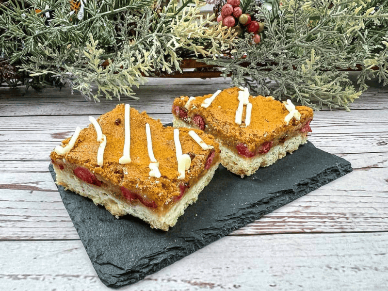 Two squares of cranberry bars on a slate plate.
