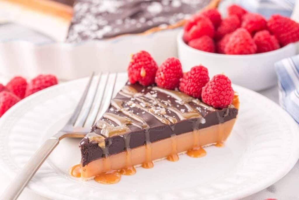 A piece of chocolate cake with raspberries on top.