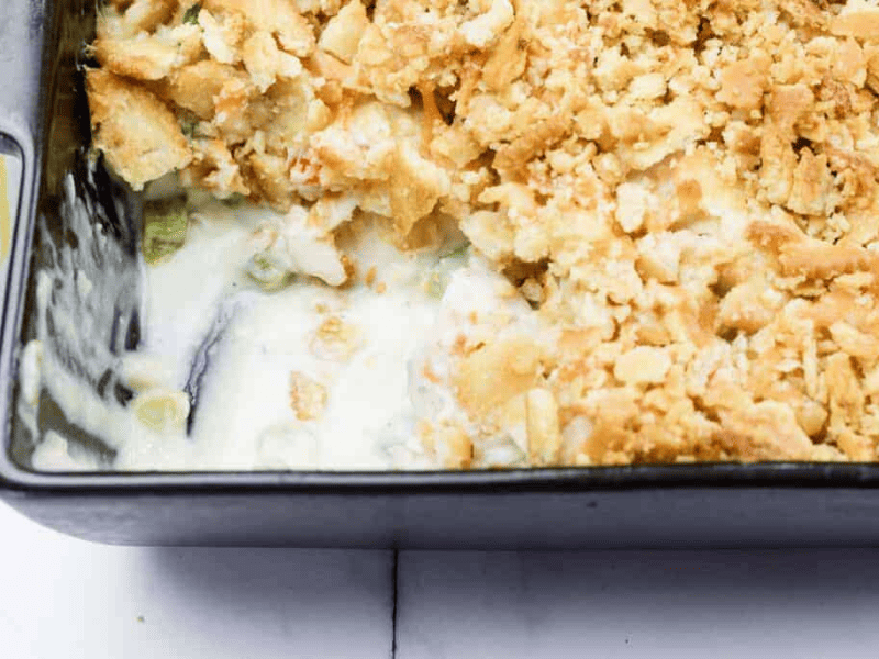 A close-up of a Cheesy Ritz Cracker Chicken Casserole dish with a portion missing from one side.