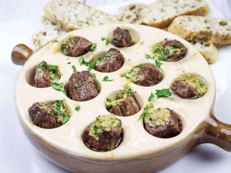 Escargot-style Garlic Butter Steak Bites in a round dish.