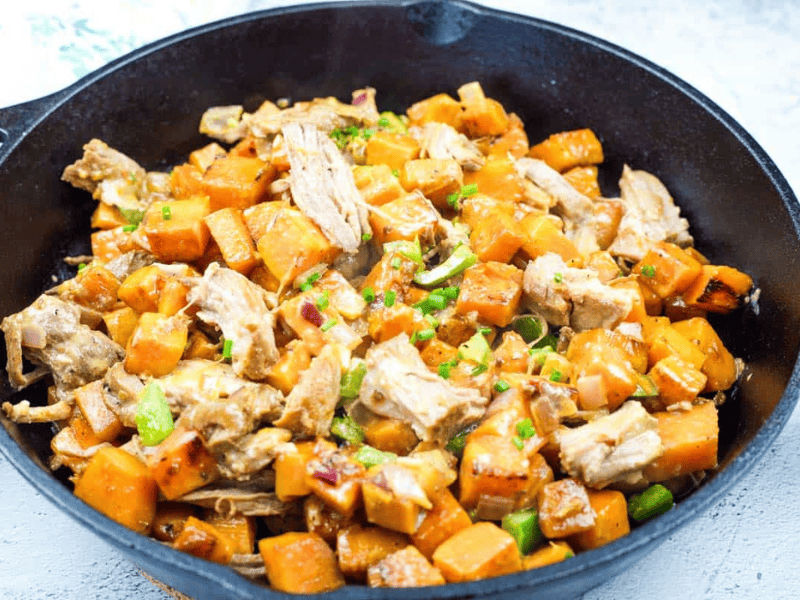 A cast-iron skillet with pulled pork and sweet potato hash.