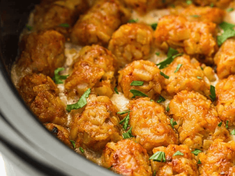 Close-up of Slow Cooker Cowboy Casserole garnished with chopped parsley, inside a slow cooker.
