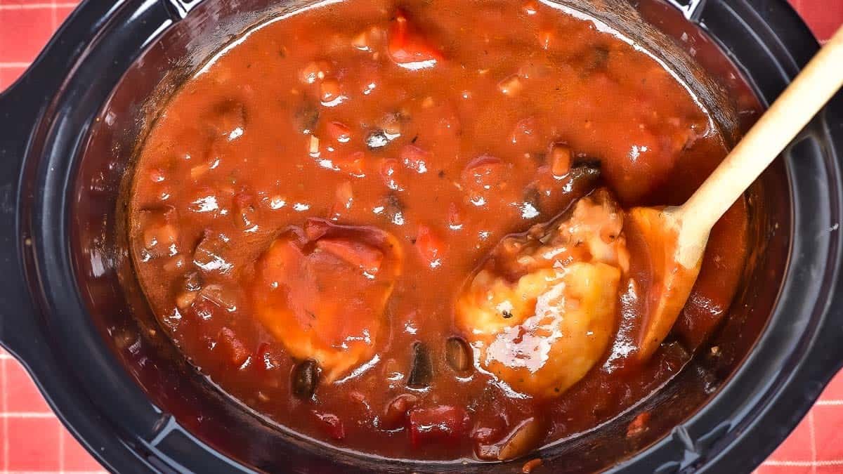 Chicken legs and thighs in a the slow cooker with tomato sauce.