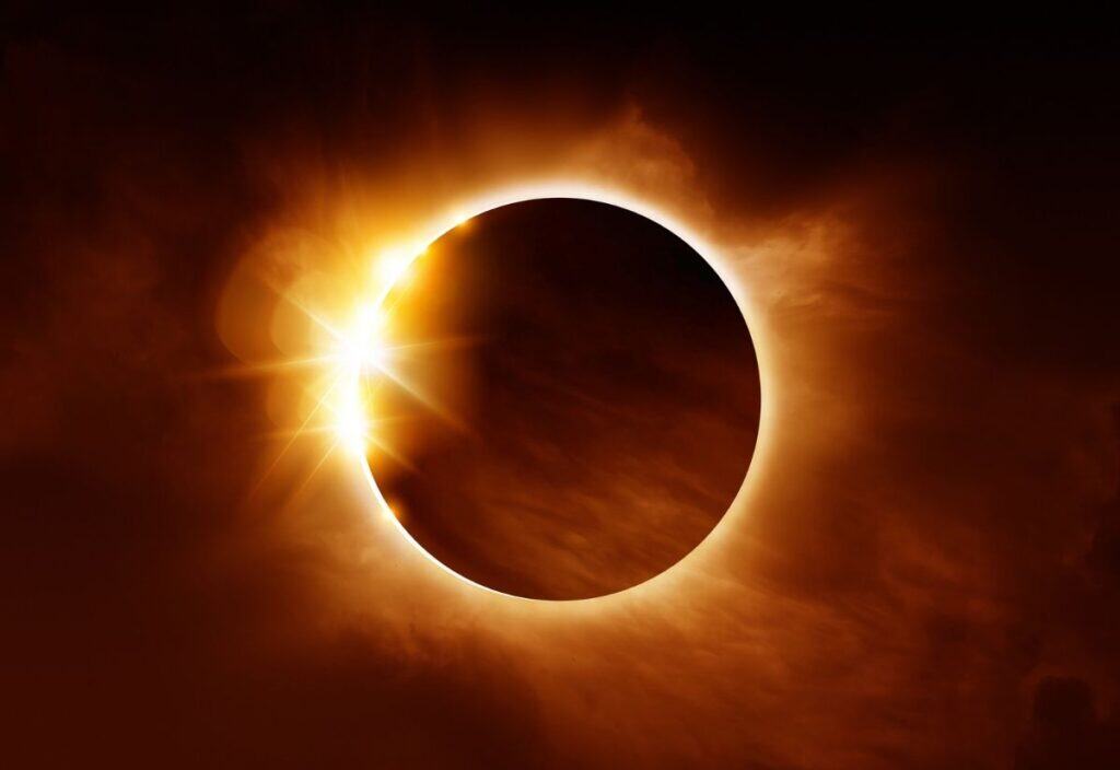 A solar eclipse with the Moon almost fully covering the Sun, leaving a bright corona and a burst of sunlight at the edge—a breathtaking sight for eclipse chasers.