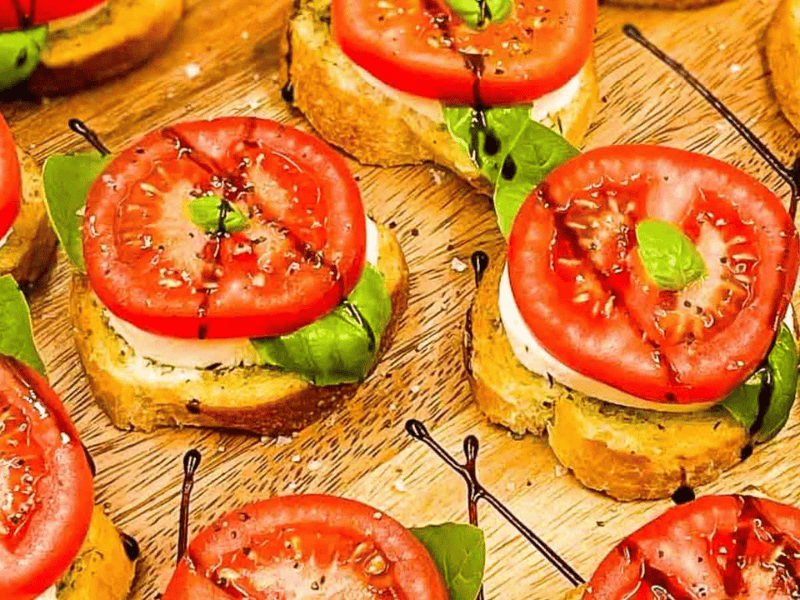 Image shows an overhead shot of Caprese Bites on a wooden board.