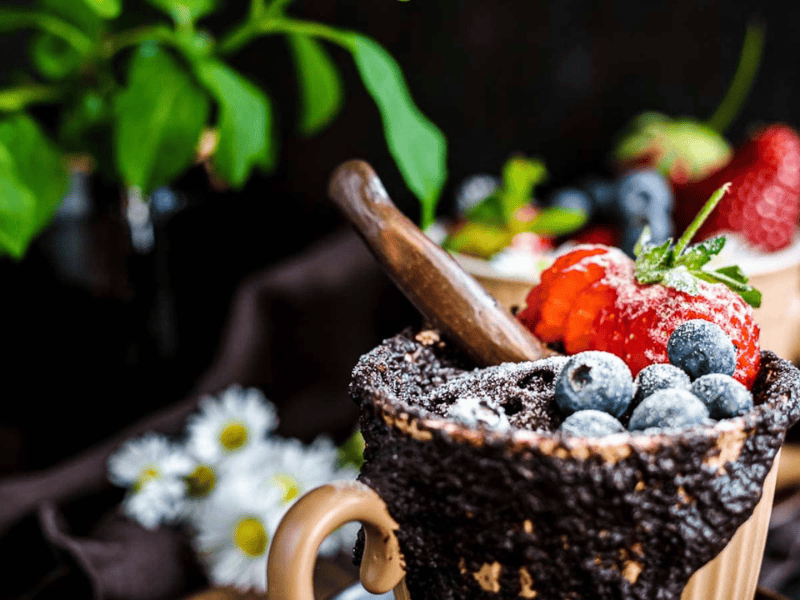 Chocolate Mug Cake with berries on top.