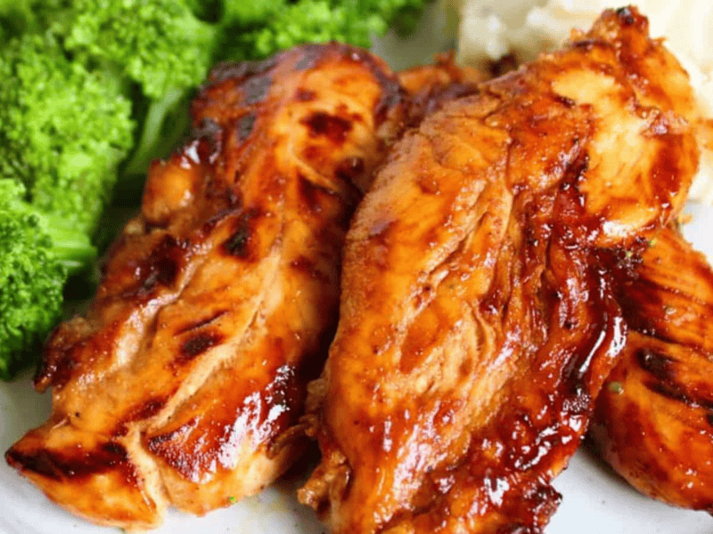 A plate with honey chicken tenders, broccoli florets, and mashed potatoes.
