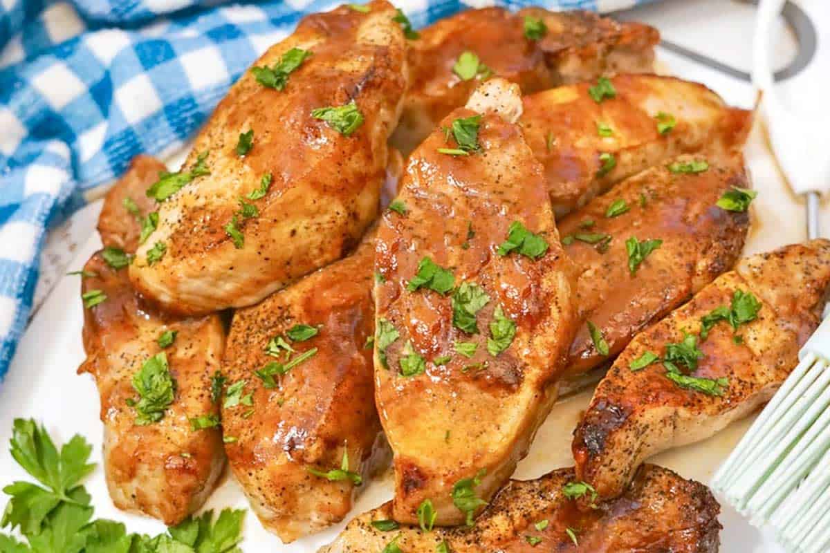 A white plate with air-fried country style ribs, garnished with barbecue sauce and parsley.