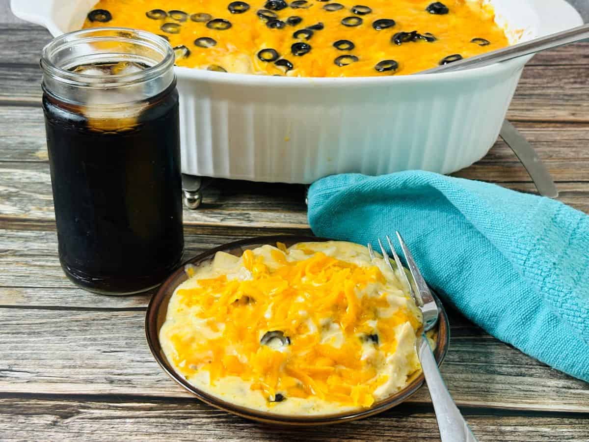 A baked casserole topped with melted cheese and garnished with fresh cilantro in a white rectangular dish.