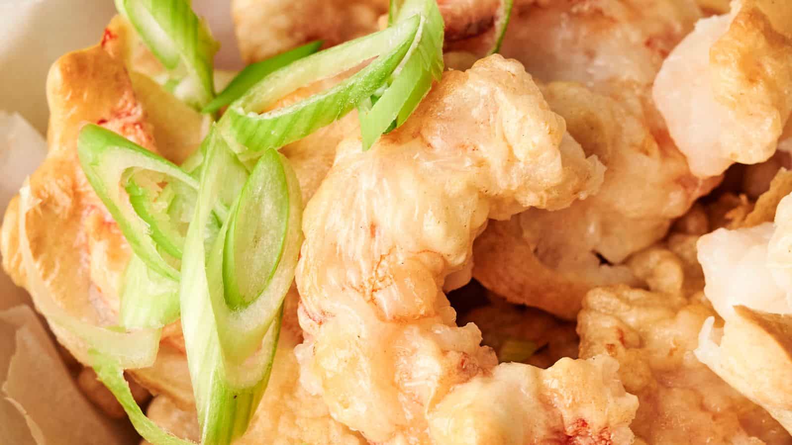 Close-up of fried shrimp topped with sliced green onions.