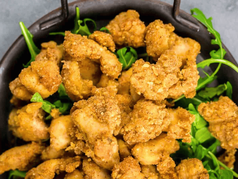A bowl of golden-brown fried chicken pieces.