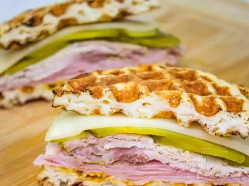 Two Cuban Chaffle sandwiches on a cutting board.
