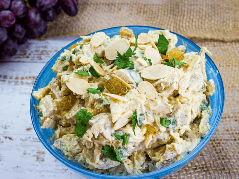 Curried chicken salad in a blue bowl.