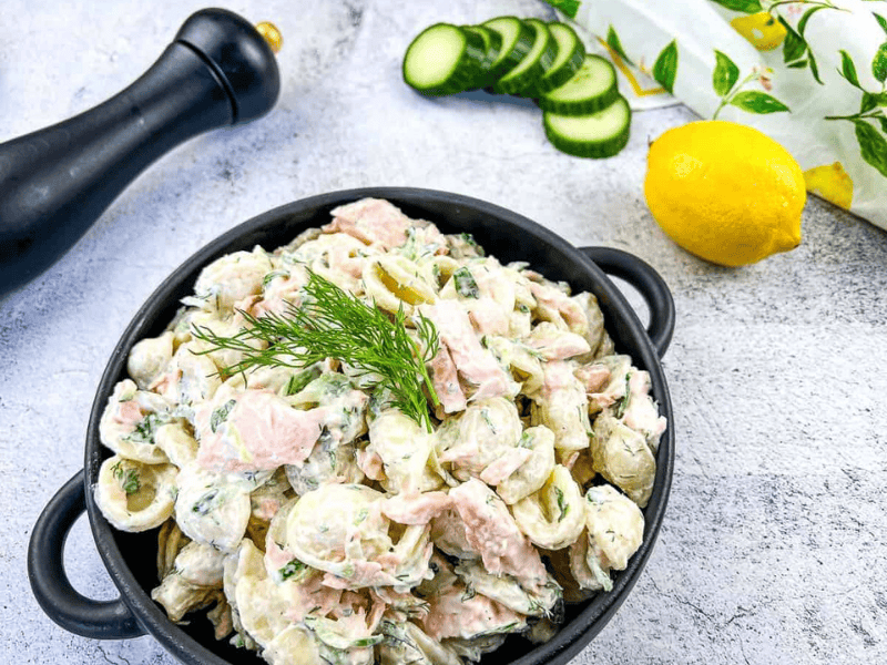Salmon pasta salad in a black dish.