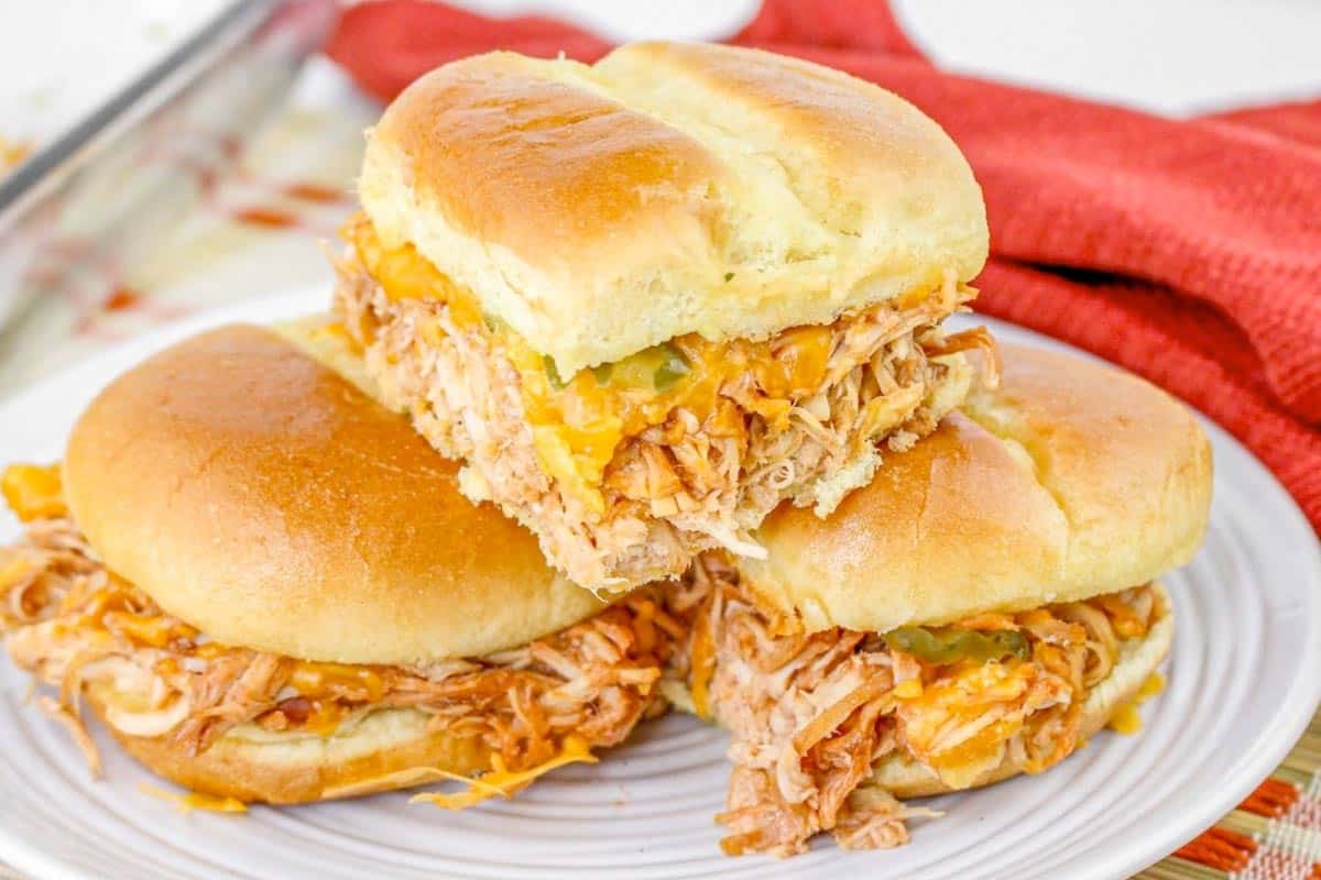 3 BBQ chicken sliders on a white plate.
