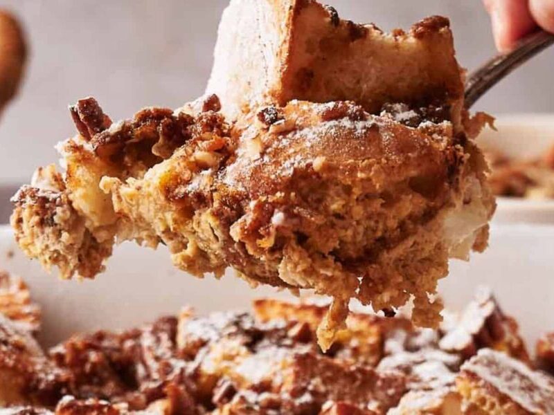 A person taking a portion of French toast casserole.