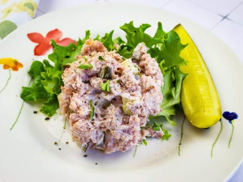 Ham Salad with dill pickle on a plate.