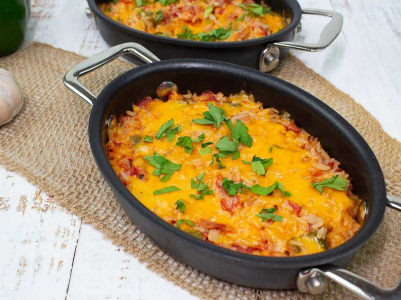 Baked Spanish Rice in two black baking dishes.