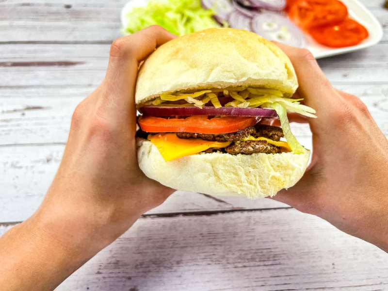 A burger held in two hands.