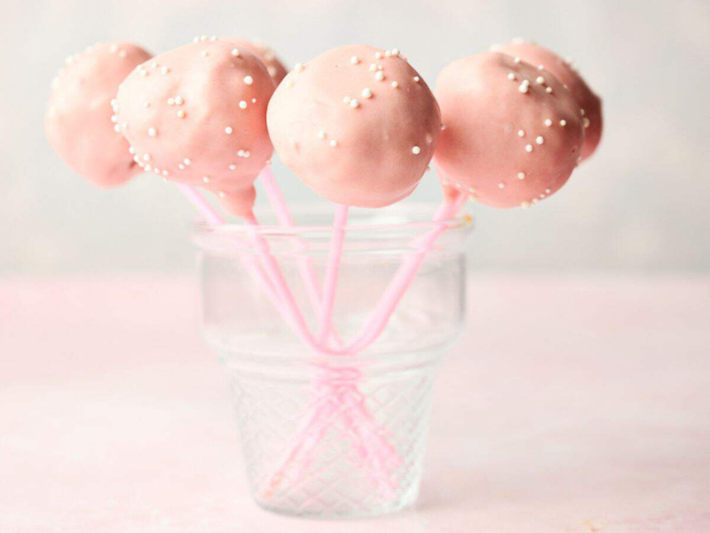 Starbucks pink cake pops in a glass on a table.