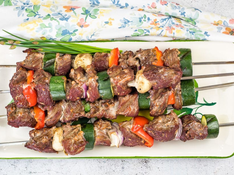 Smoked beef kabobs on a plate.