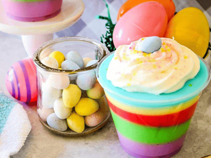 A colorful easter dessert in a cup with eggs and candy.