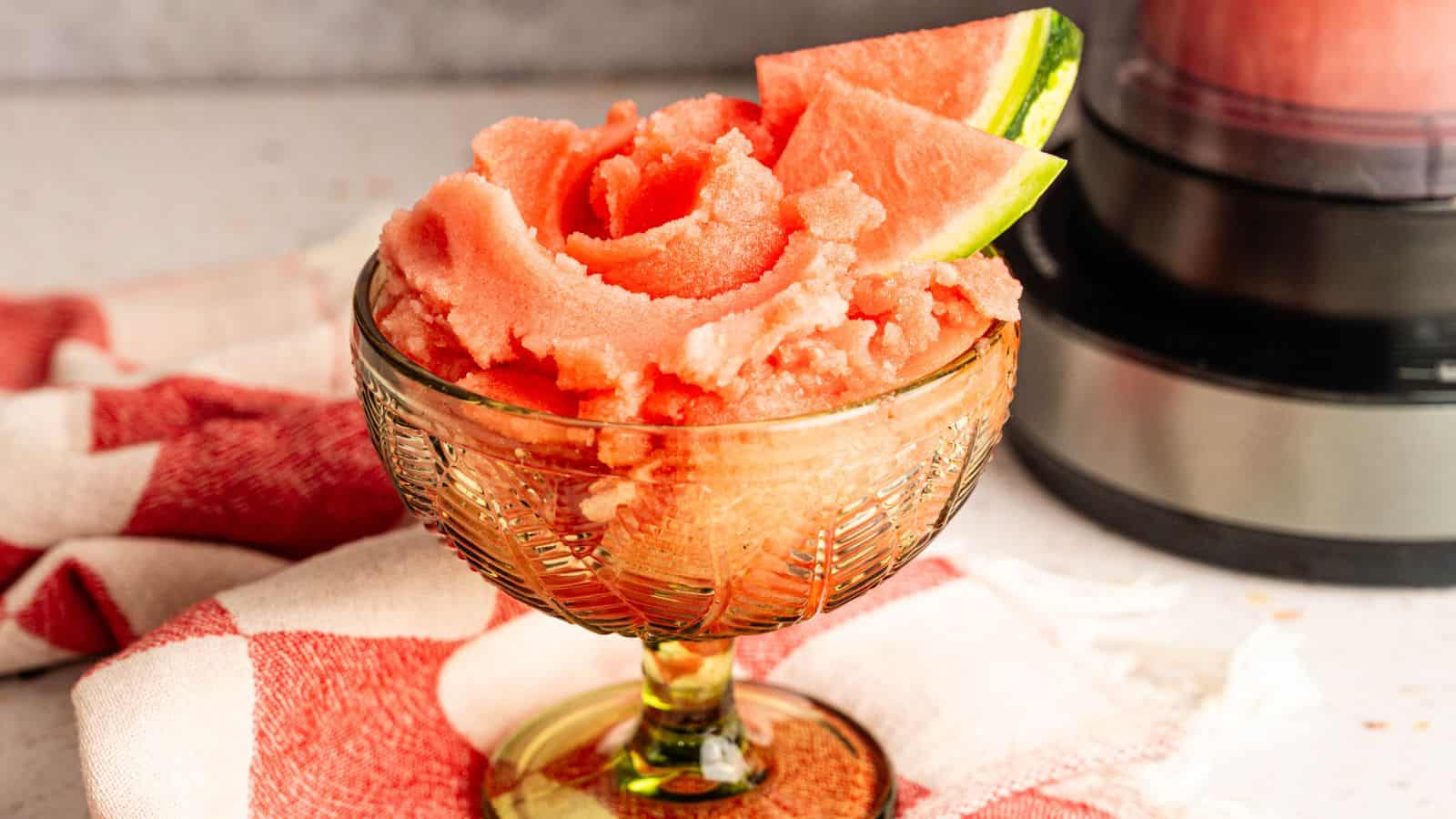 Delicious homemade watermelon sorbet served in a glass bowl with watermelon slices.