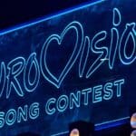 Neon blue sign displays the words "Eurovision Song Contest" with a heart shape replacing the "v" in "Eurovision.