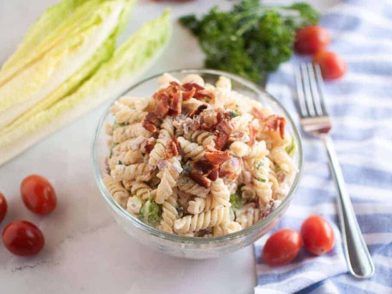 Overhead shot of a glass bowl filled with BLT pasta salad.