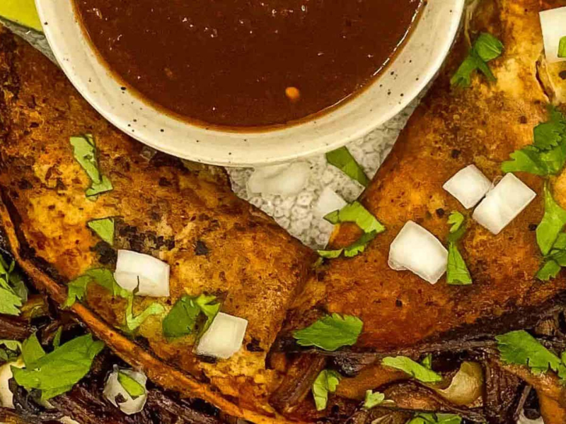 A plate of tacos with a sauce on it.