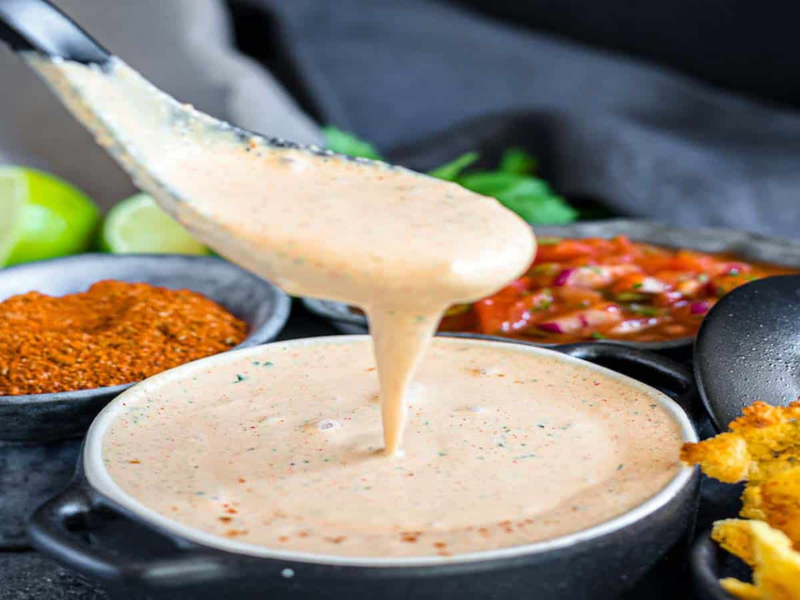 Easy Healthy Creamy Salsa Dressing in a dish with a spoon dishing it up.
