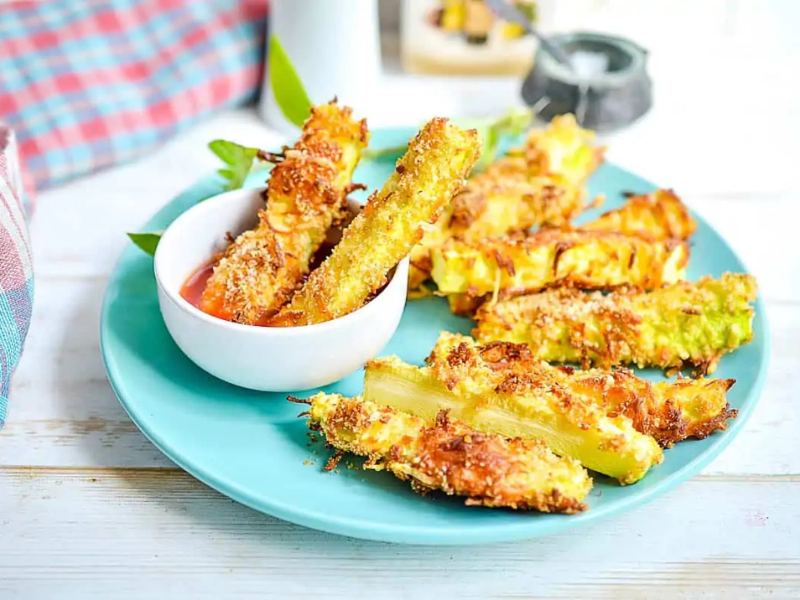 Zucchini fries on a plate with dipping sauce.