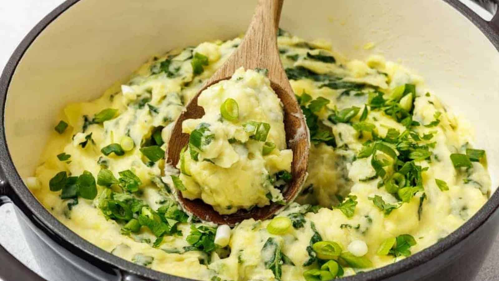 A pot of Colcannon with Kale, with a wooden spoon lifting a portion.