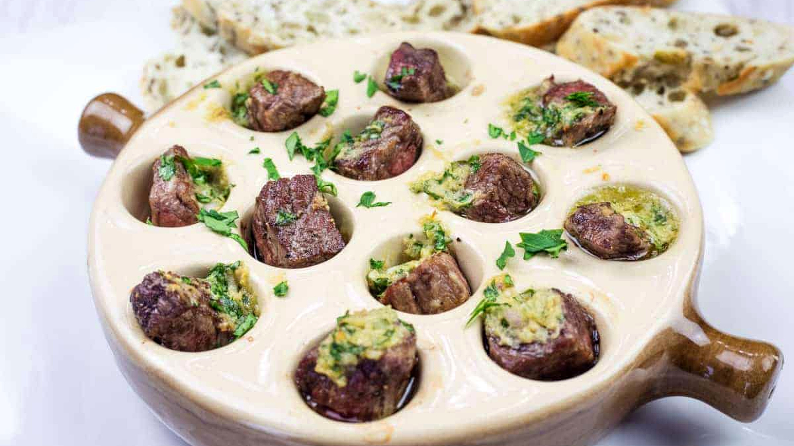 Escargot-style Garlic Butter Steak Bites in a round dish.