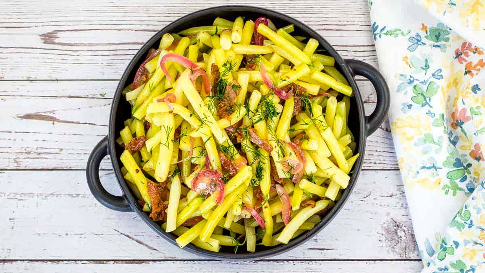 A bowl of German yellow beans on a wooden table.