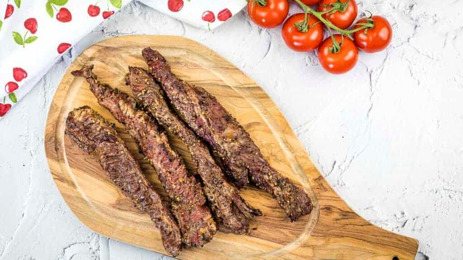 Grilled Beef Finger Meat on a wooden cutting board.