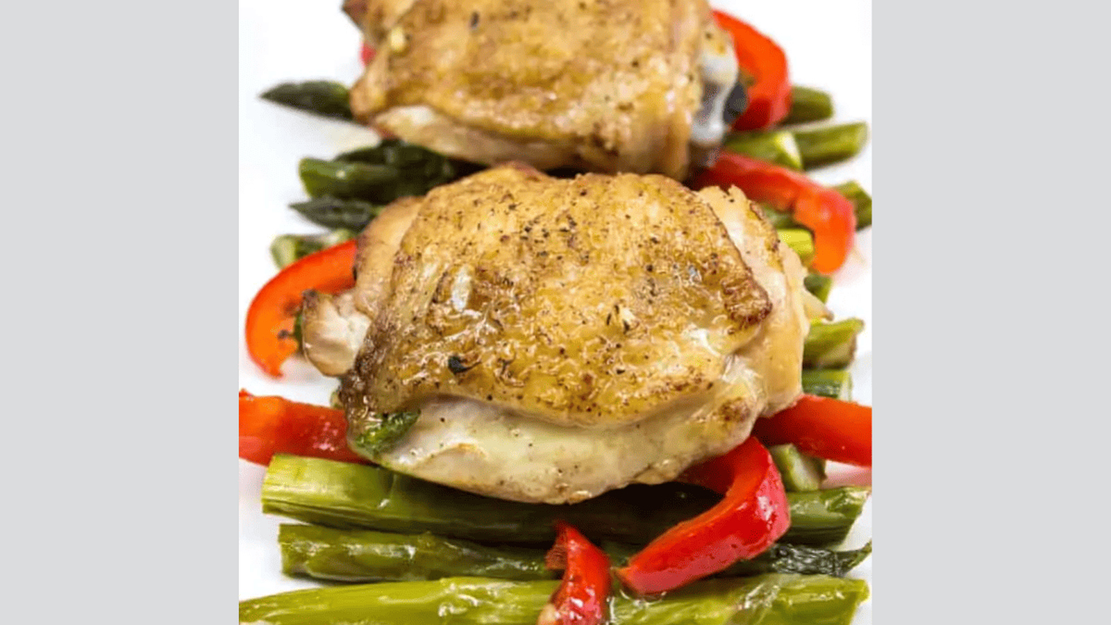 Garlic Chicken Skillet with peppers and asparagus on a white plate.